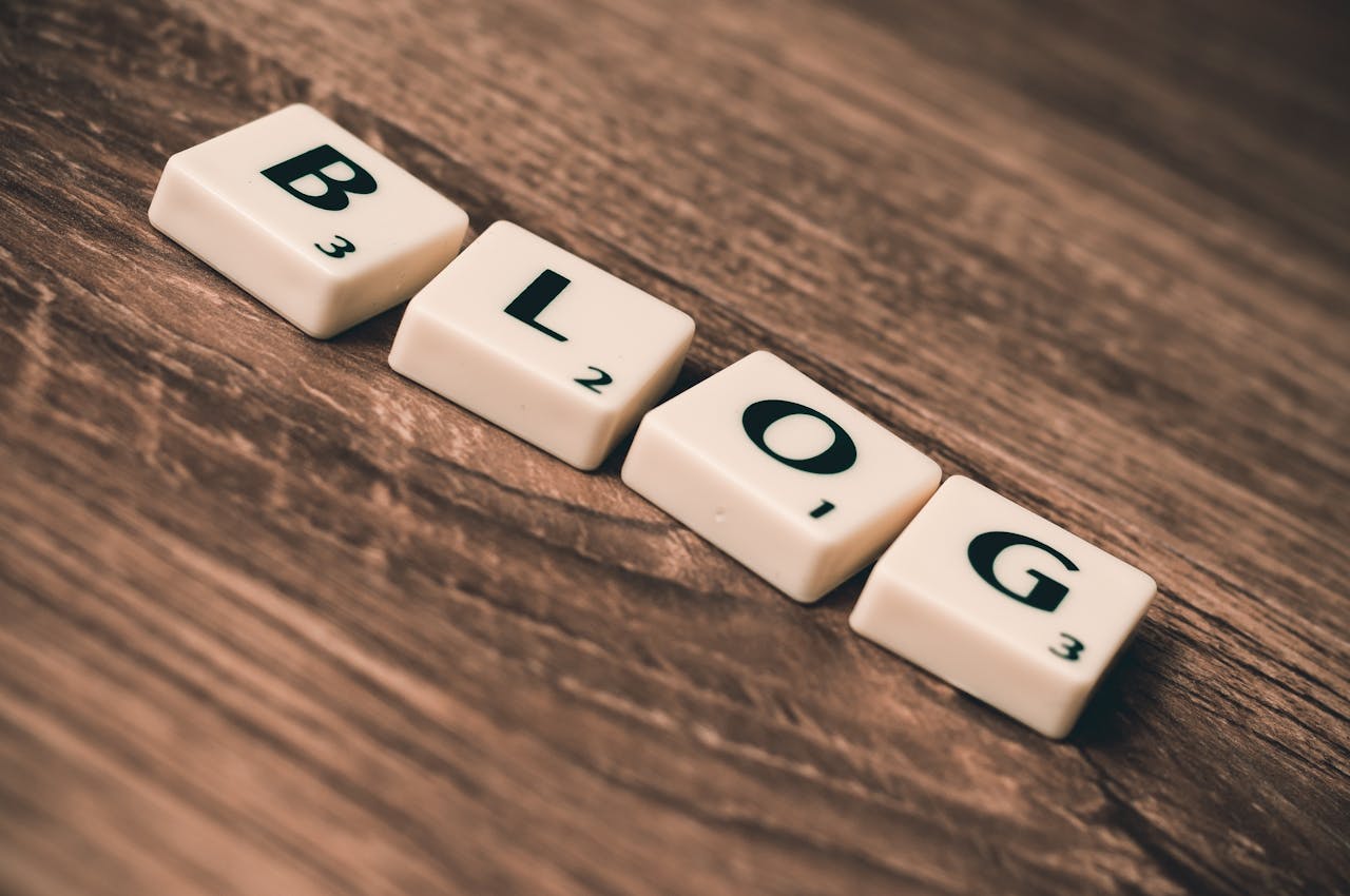 about-us Scrabble tiles spelling 'BLOG' on a wooden background, symbolizing creativity and writing.