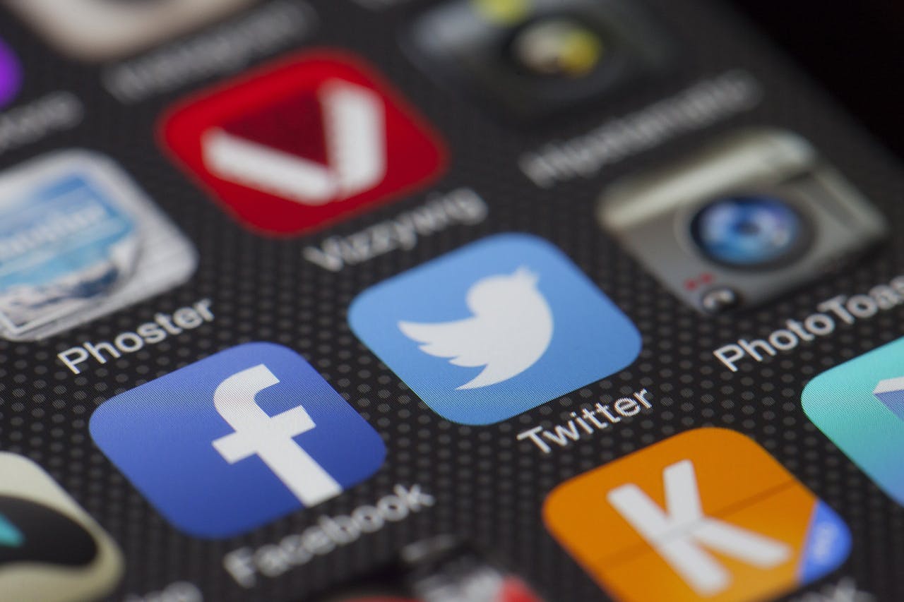 about-us A detailed close-up of social media icons on a smartphone screen, including Facebook and Twitter.