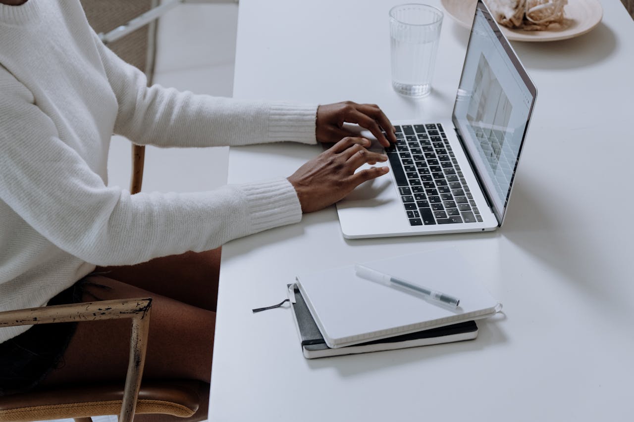 who-we-are A person typing on a laptop in a minimalistic home office setting, capturing modern work culture.